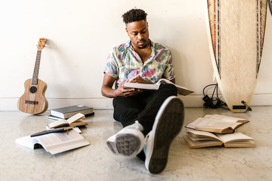 Man reading books while sitting on the floor