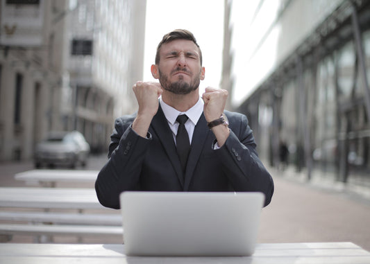 A guy raising his hands being happy about reaching his career goals!